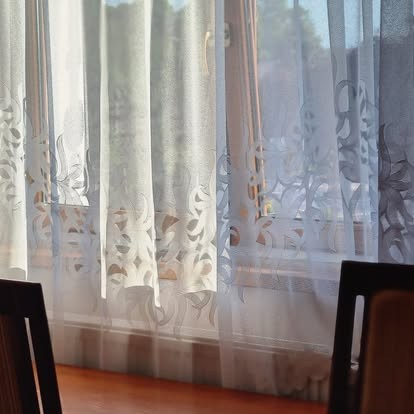 Okno z firanami i krzesła we wspólnym pomieszczeniu